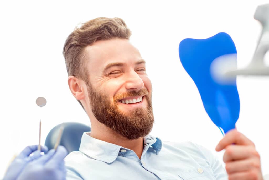 new patient smiling with mirror